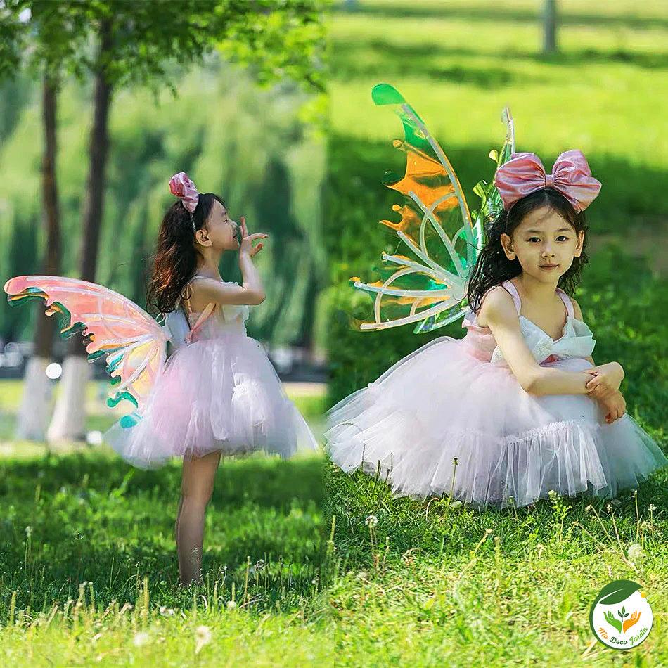 Ailes de FEE lumineuses colorées sur une petite fille en robe de fête, parfaites pour des événements magiques en extérieur.