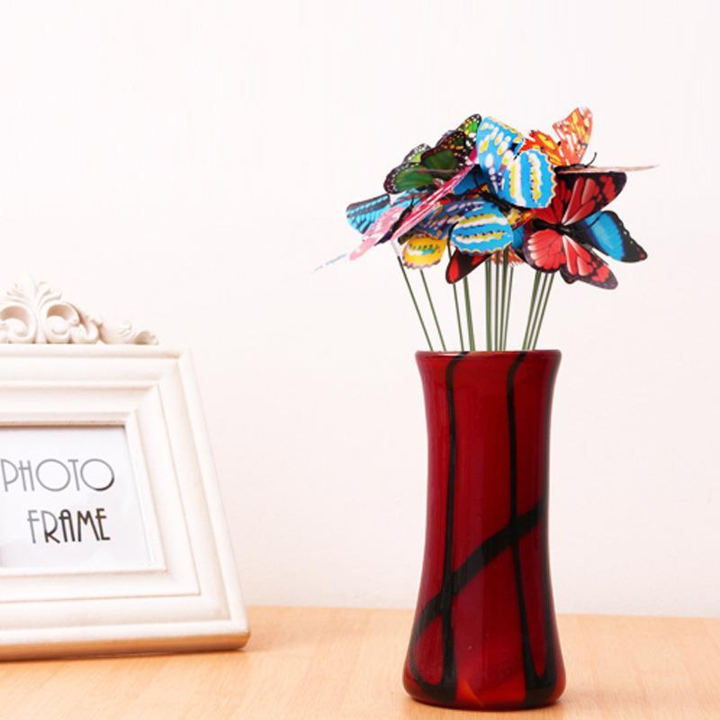 Bouquet de papillons multicolore dans un vase rouge élégant, ajoutant une touche de couleur et de vie à votre décor