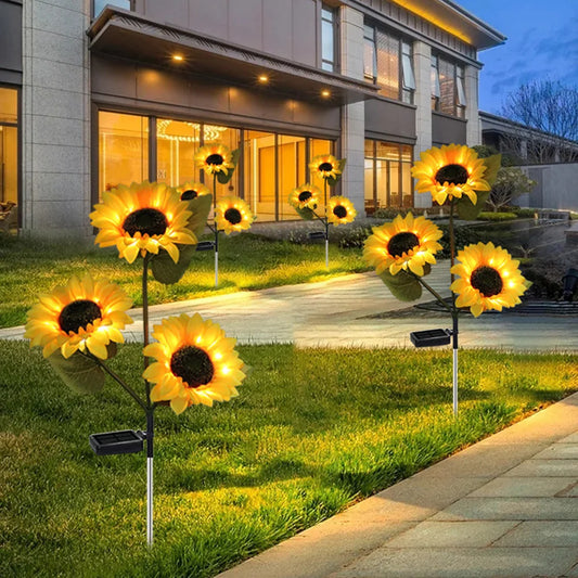 Lampe LED tournesol en fleurs illuminant un jardin, ajoutant une ambiance chaleureuse et accueillante à l'extérieur
