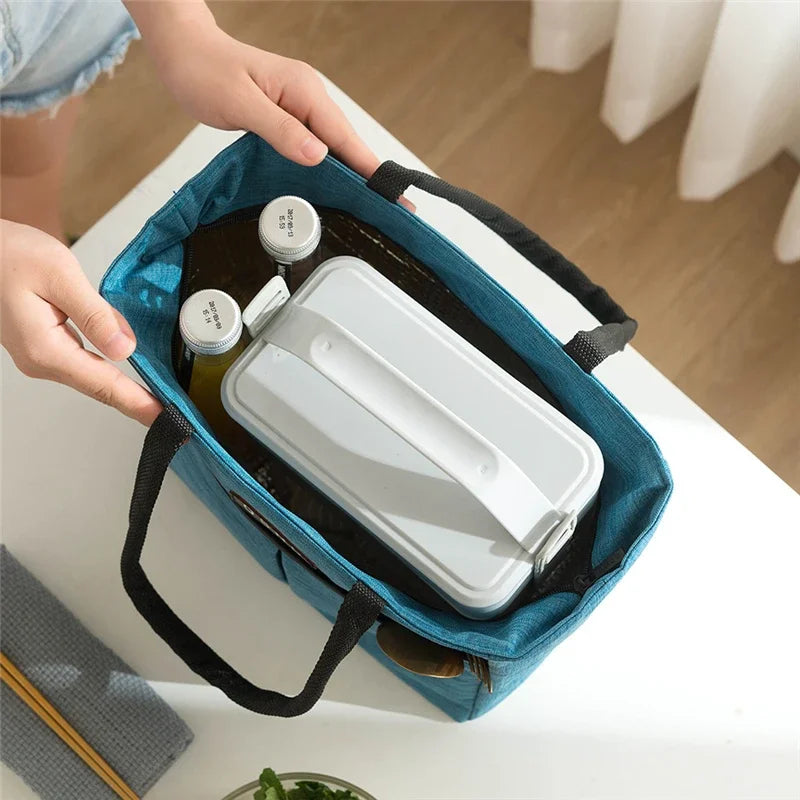 Sac isotherme portable en bleu contenant des bouteilles et un récipient hermétique, idéal pour le pique-nique