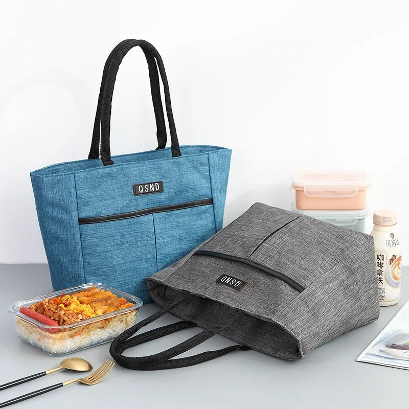 Sac isotherme portable en bleu et gris, parfait pour transporter des repas et boissons, avec des poches pratiques.