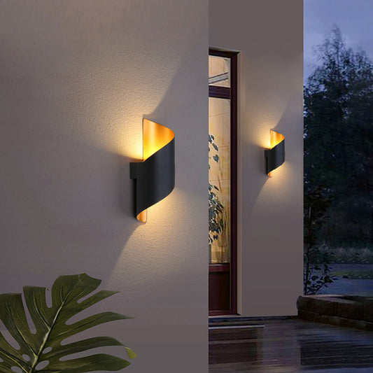 Applique murale de luxe noire en métal avec un design enroulé, éclairage chaleureux pour une ambiance élégante.