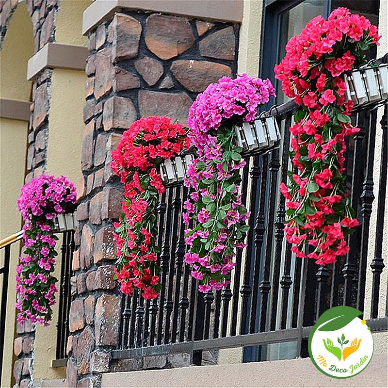 Jolies fleurs artificielles haut de gamme suspendues à une balustrade, ajoutant une touche de couleur à un balcon.