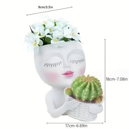 Pot de fleur original pour plantes en forme de visage artistique, avec des cactées et des fleurs blanches dans un design moderne
