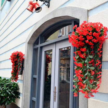 Fleurs artificielles haut de gamme en pot rouge, accrochées à une façade, apportant une touche colorée et élégante au jardin