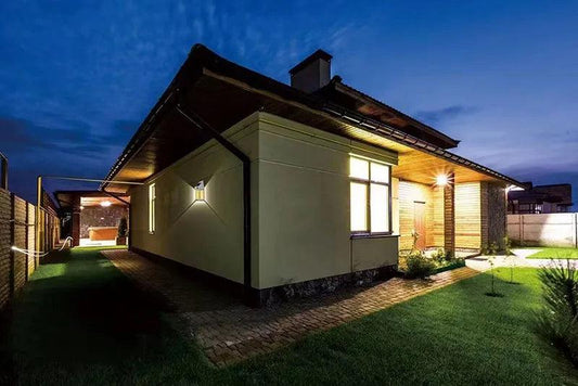 LAMPE LED exterieure MURLAID éclairant un jardin autour d'une maison moderne au crépuscule, créant une ambiance agréable