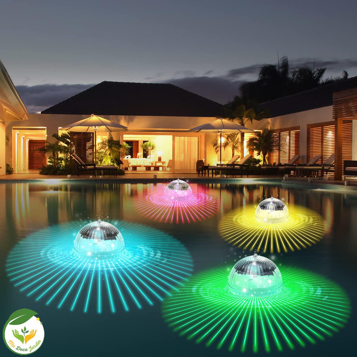 Quatre lampes flottantes LED pour piscine émettant des lumières colorées multicolores sur la surface de l'eau, créant une ambiance festive.