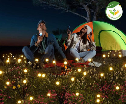 Lampe solaire décorative jardin illuminant une scène de camping élégante avec des couples assis entourés de fleurs et d'une tente colorée
