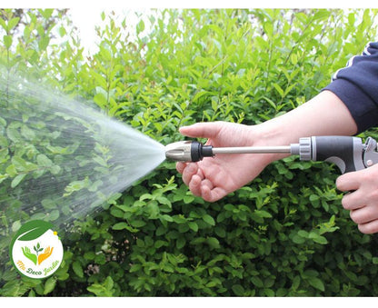 Pistolet à eau haute pression portable en action, projetant un jet d'eau puissant à travers une verdure luxuriante