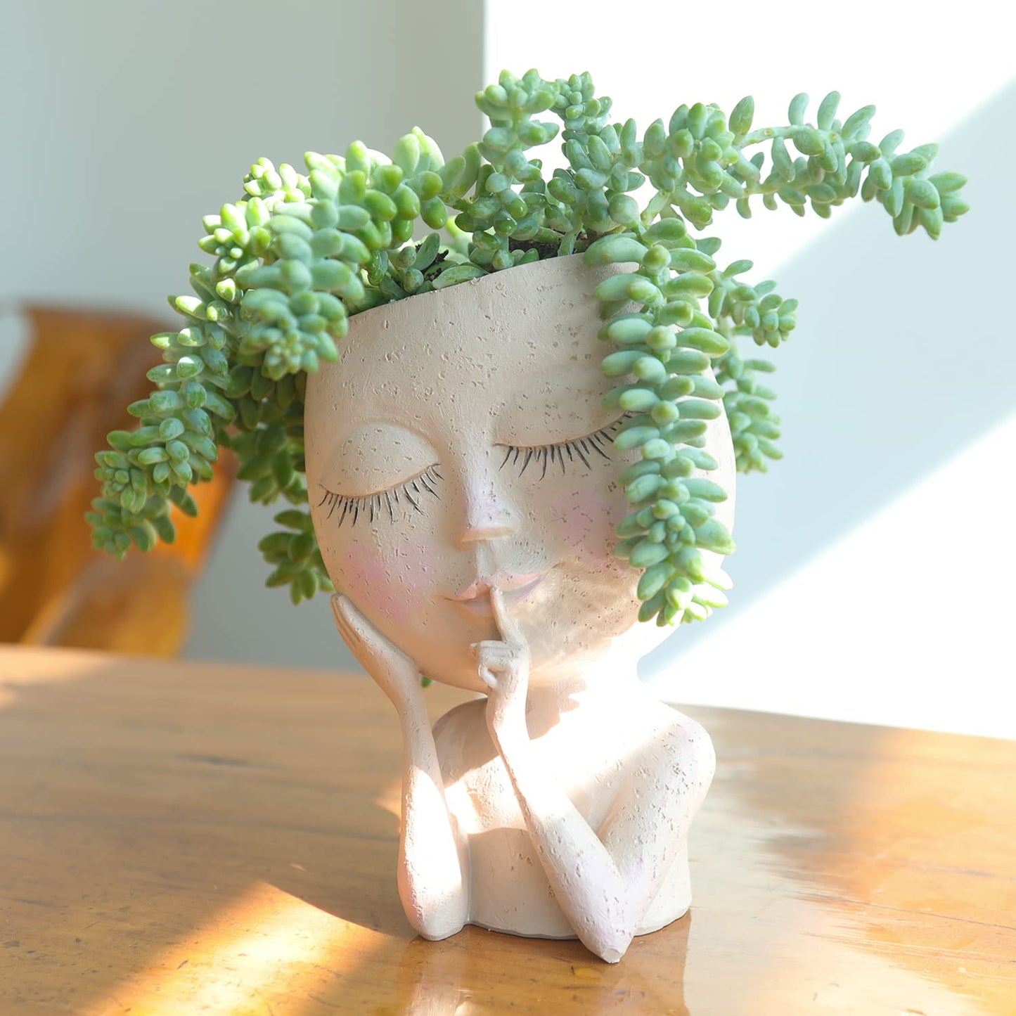 Pot de fleurs visage femme en céramique beige avec plante succulente, ajoutant une touche de décoration artistique
