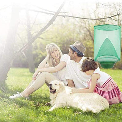 Attrape mouches écologiques en plastique vert utilisé dans un jardin, avec une famille heureuse et un chien pendant une journée ensoleillée.