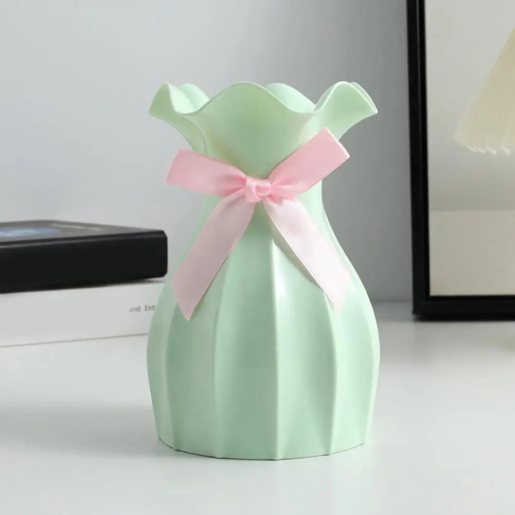 Vase à fleurs design élégant en vert menthe avec un nœud rose, idéal pour embellir votre intérieur.