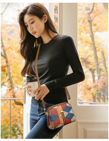 Sac bandoulière femme chic avec motifs colorés porté par une femme en noir, parfait pour accessoires mode femme chic