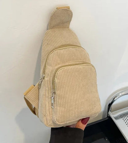 Sac bandoulière tendance en matière côtelée beige avec plusieurs poches, un accessoire de mode pour femme élégant.