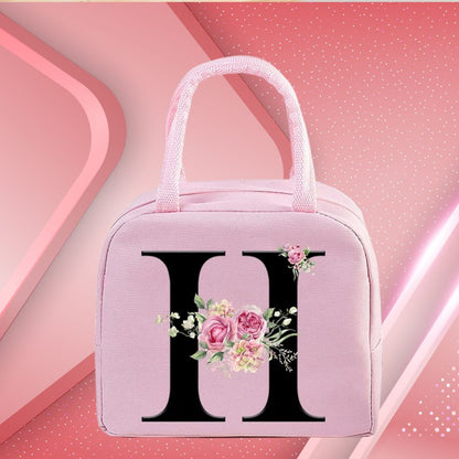 Sac isotherme rose avec motif floral et initiale noire, idéal pour le déjeuner ou les pique-niques