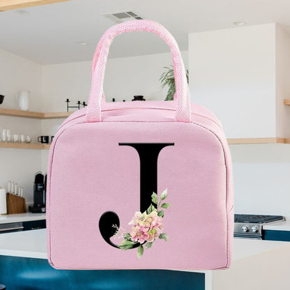 Sac isotherme rose avec une initiale J et des décorations florales, idéal pour les déjeuners en déplacement