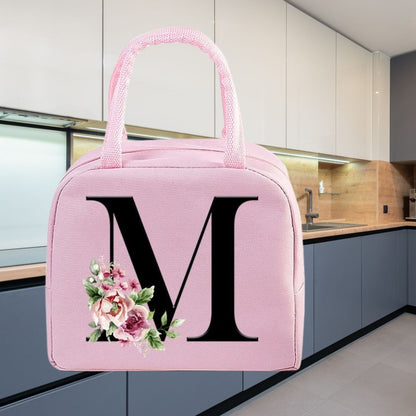 Sac isotherme rose avec un motif floral et une grande lettre M, idéal pour garder vos repas au frais