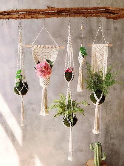 Support pot de fleur suspendu en macramé avec des plantes vertes et des fleurs pour une décoration naturelle moderne