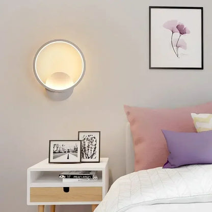 Applique murale LED moderne design circulaire éclairant une chambre avec lits et décorations esthétiques