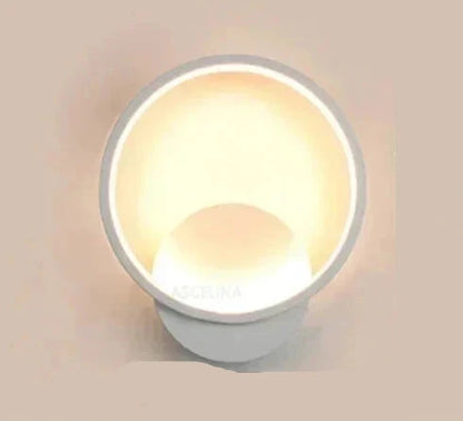 Applique murale LED moderne de forme circulaire, offrant une lumière douce et ambiante pour une chambre élégante