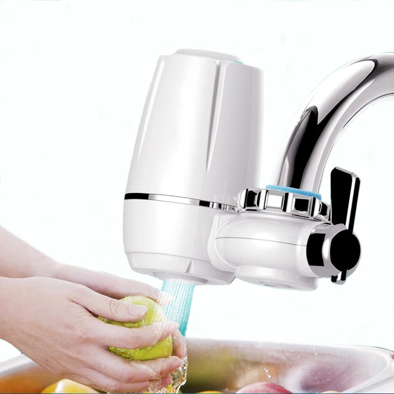 Filtre eau robinet cuisine installé sur un robinet, avec une main lavant des fruits sous un jet d'eau purifiée