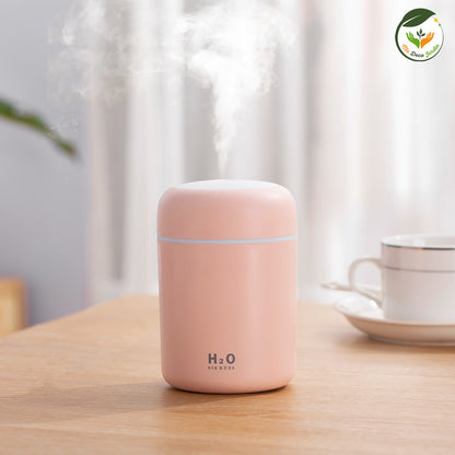 Diffuseur d'huiles essentielles en rose pastel émettant de la vapeur douce, idéal pour humidifier l'air