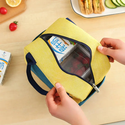 Sac isotherme enfants avec une fermeture éclair jaune et une main qui l'ouvre pour révéler des snacks à l'intérieur