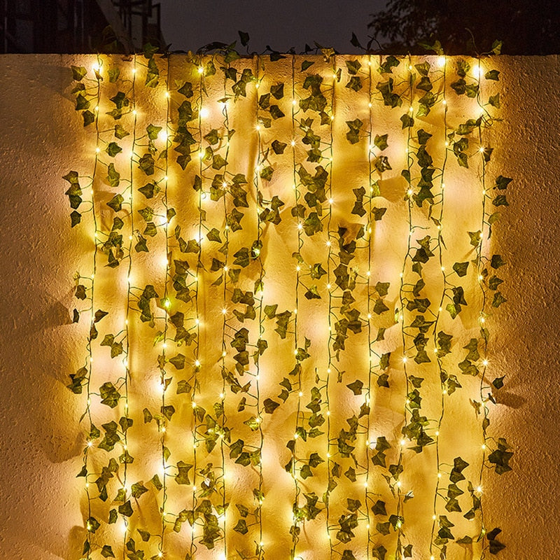 Guirlande solaire exterieur avec des lumières chaleureuses et des feuilles décoratives pour créer une ambiance jardin accueillante.