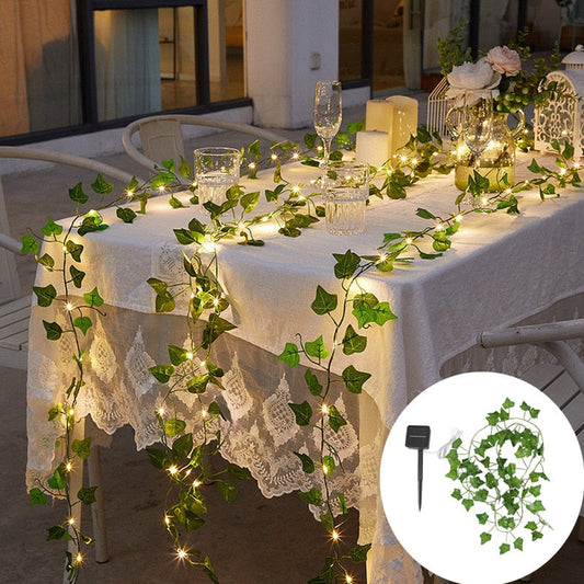 Guirlande solaire exterieur illuminant une table de jardin avec des feuilles vertes et une ambiance romantique